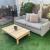 Outdoor rattan sofa with cushions and wooden table